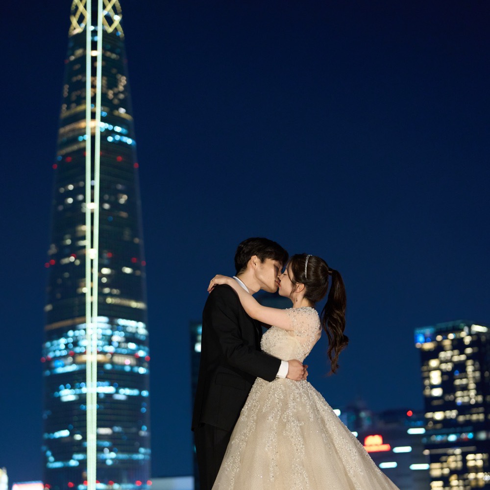 夜景をバックにキスを交わす新郎新婦